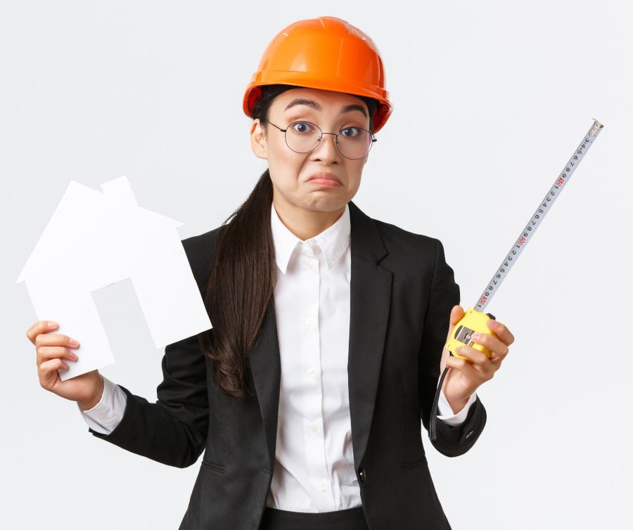 Confused indecisive asian female architect dont know what do, engineer in helmet and business suit shrugging while holding home maket and measuring tape, white background 4. Brak planu wdrożenia w zasady działania organizacji