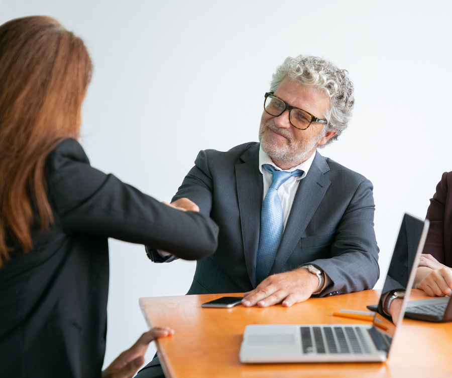 Szef podaje dłoń pracownikowi - relacja między pracodawcą a pracownikiem